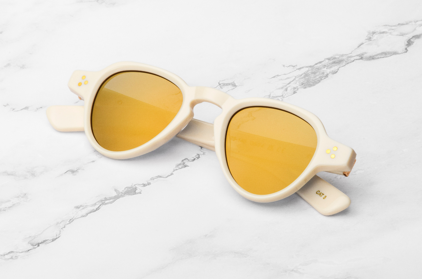 creamy white round sunglasses with mirrored gold lenses