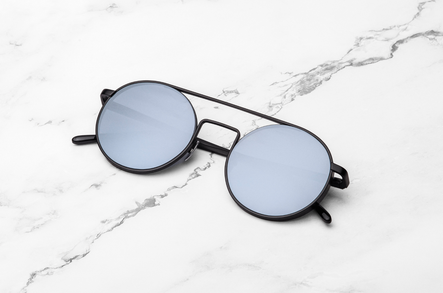 Black round sunglasses with silver mirrored polarized lenses by Kopajos