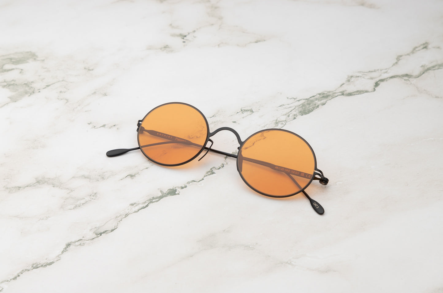 Black oval sunglasses for men and women with polarized orange lenses by Kopajos