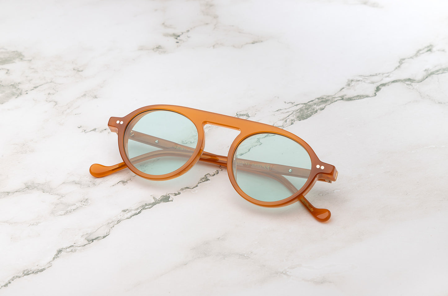 Front view of the Peter Frank orange round sunglasses showing the temple detail.