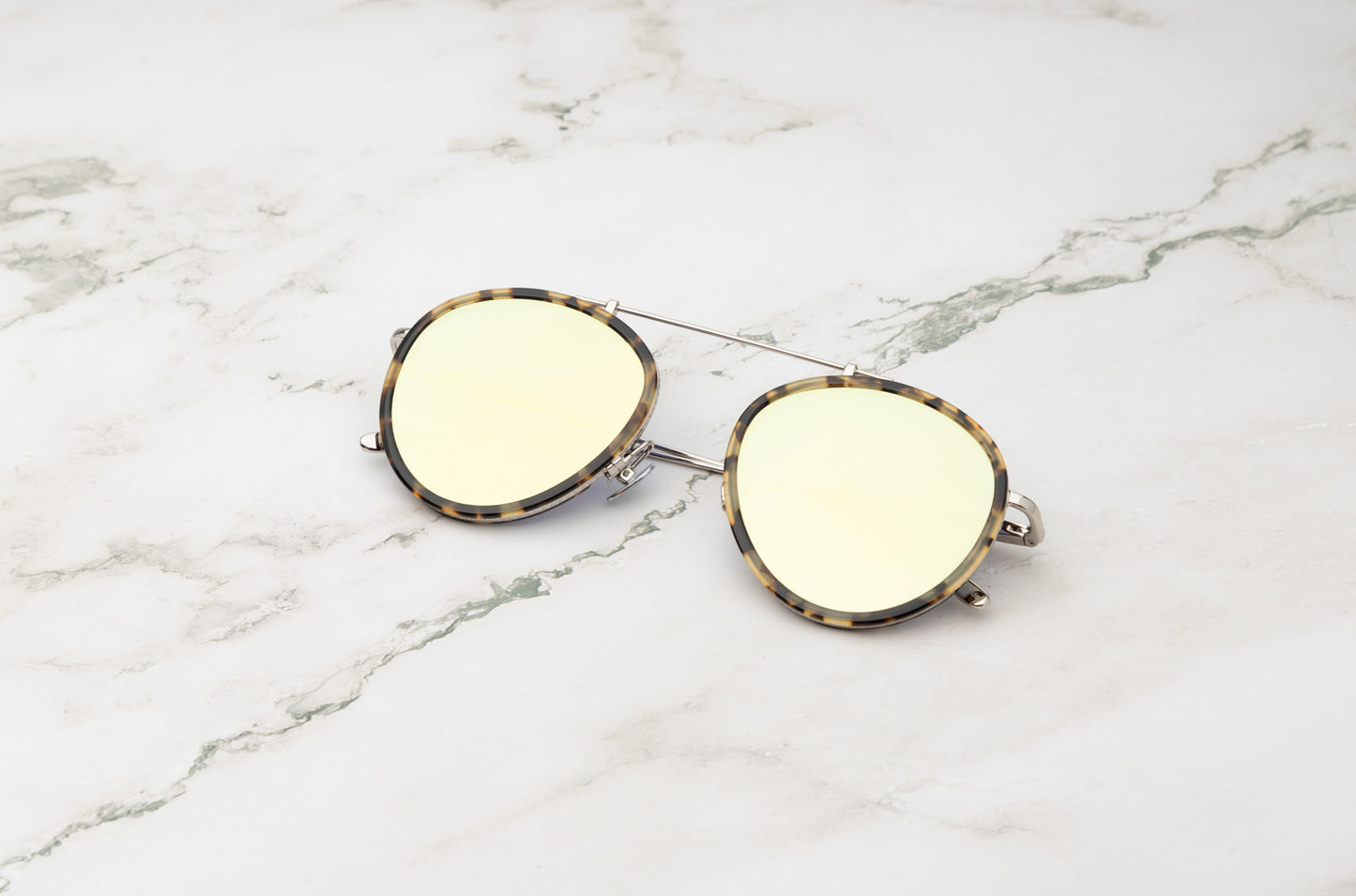 A close-up showing the mirror lenses on the Sasha Davidov silver aviator sunglasses.