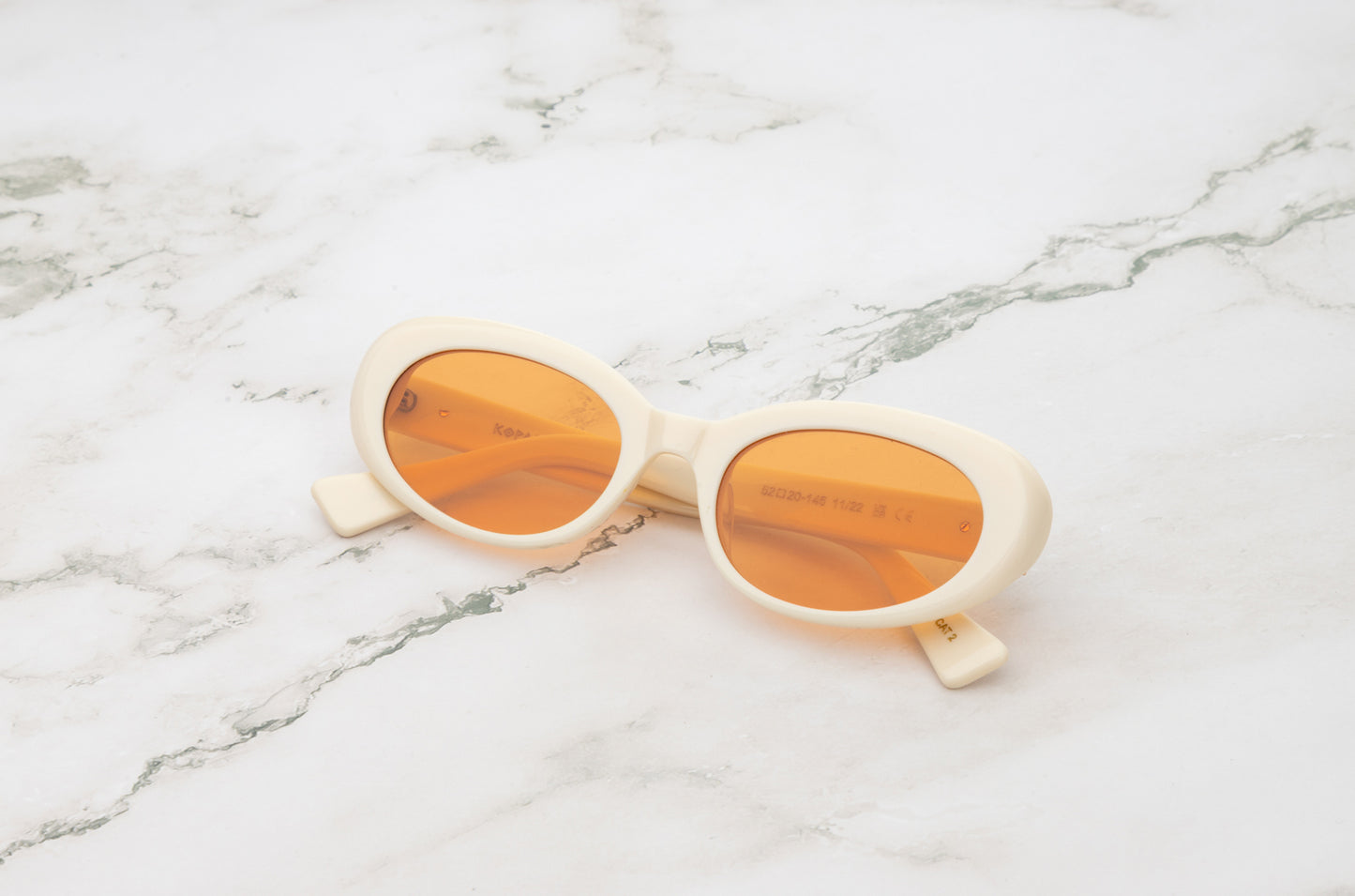 Lina round sunglasses by Kopajos with white frame and transparent orange polarized lenses for men and women.