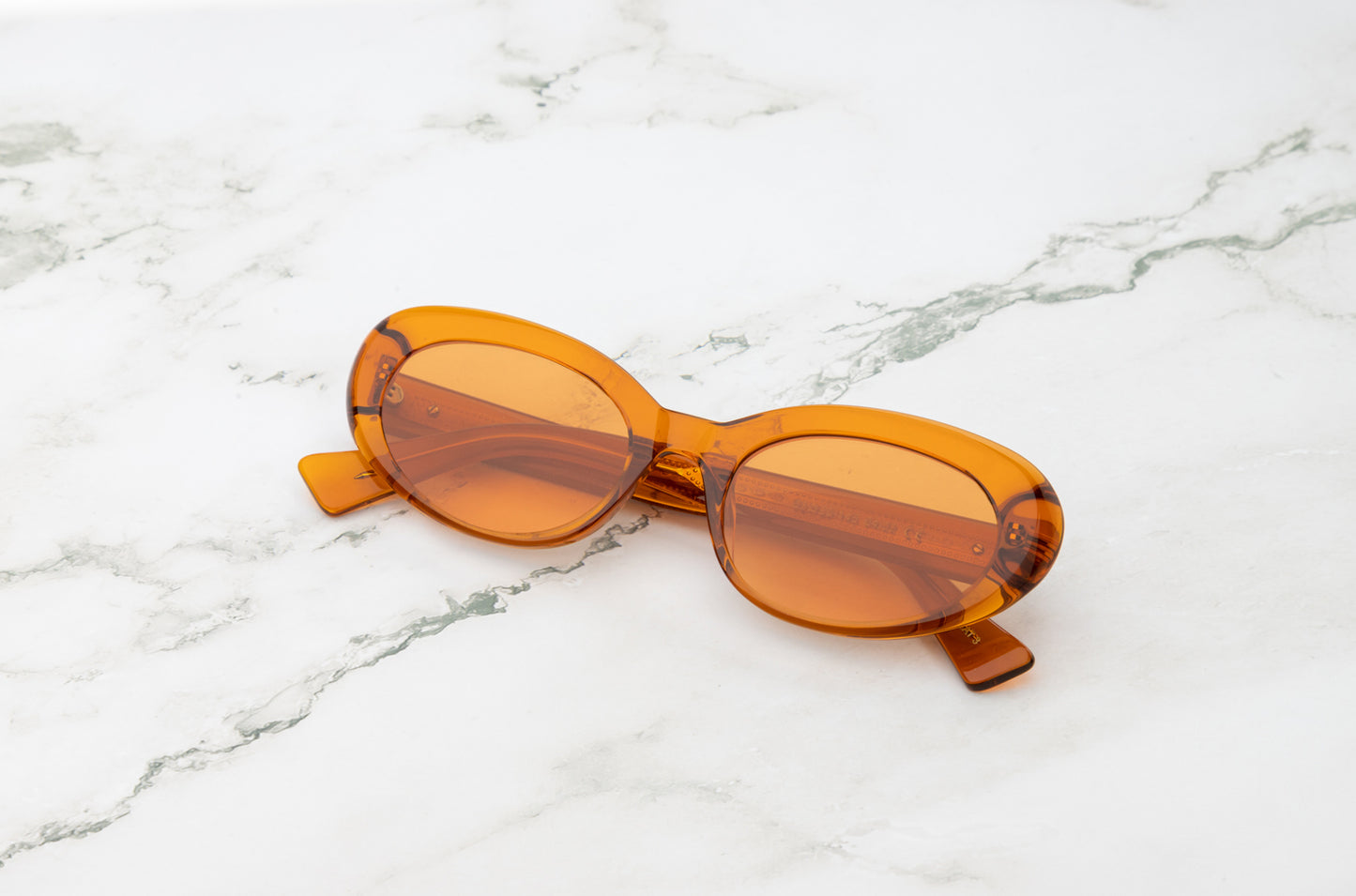 Lina round sunglasses by Kopajos with brown transparent frame and orange transparent polarized lenses for men and women.