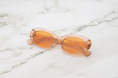 Lina round sunglasses by Kopajos with transparent pink frame and orange transparent polarized lenses for men and women.