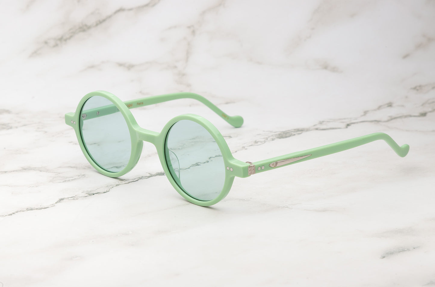 A pair of green round sunglasses, the Petra model by Kopajos.