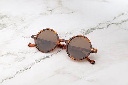 The polarized lenses of the Kopajos Petra retro round sunglasses, ideal for Santorini's sun.
